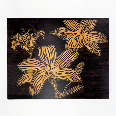 A square decorative cutting board art piece featuring stylized maple wood lily flowers on black walnut wood board, shown against a plain white background.
