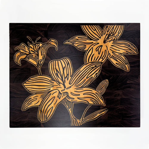 A square decorative cutting board art piece featuring stylized maple wood lily flowers on black walnut wood board, shown against a plain white background.